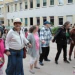 Osiem osób w różnym wieku, trzymających się za ręce