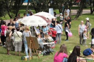 Festyn osiedlowy SM Czechów i Piknik integracyjny “Jestem wśród Was!” - uczestnicy festynu zebrani wokół stoiska Stowarzyszenia na rzecz osób potrzebujących wsparcia IUVO