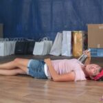 Występ grupy teatralnej „Anielinki” - na scenie leży aktorka, trzymająca butelkę wódki