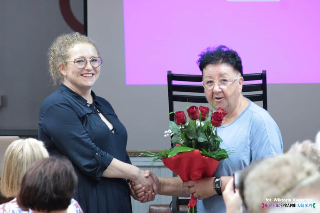 Pani Elżbieta Sagan wręcza bukiet czerwonych róż Pani Ewelinie Stachel-Miedzianowskiej
