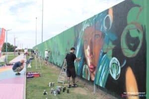 Artyści malujący na ścianie obok centrum handlowego Skende przy ul. Spółdzielczości Pracy