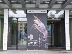 Wejście do Centrum Spotkania Kultur od Placu Teatralnego; drzwi rozsuwane z planszą wystawy "Zmysły i emocje"