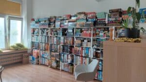 Regał wypełniony po brzegi grami planszowymi.