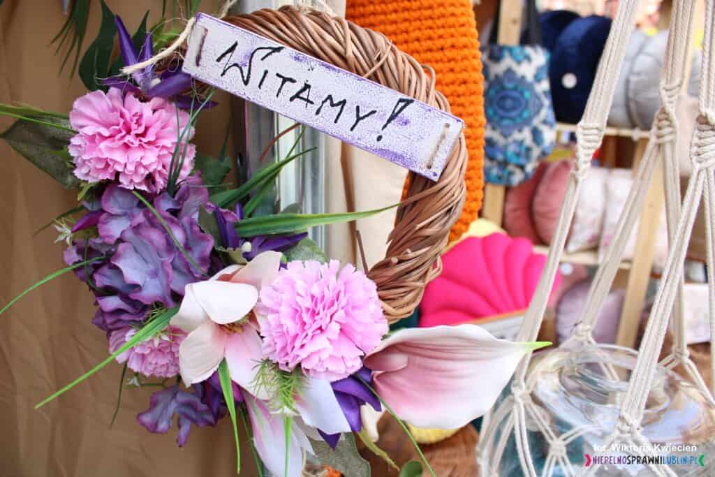 Wianek wykonany z wikliny i kwiatów z napisem "WITAMY", wykonany w Warsztacie Terapii Zajęciowej Ostrów Lubelski, Stowarzyszenie Inicjatyw Edukacyjnych "PRO EDUCATIO"