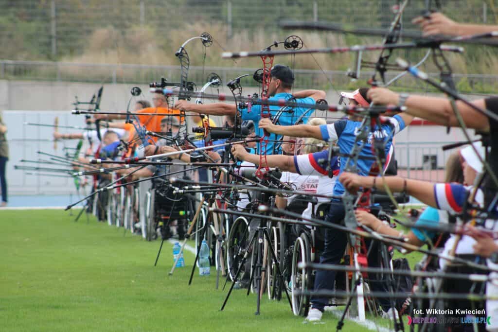 Zawodnicy trzymający przygotowane do strzału łuki