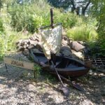 Łódka, obok tabliczka z nazwą rzeki Jordan