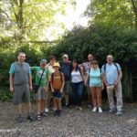 Uczestnicy wycieczki na tle krzewów