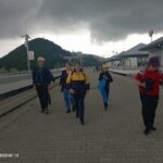 Grupa osób spacerująca po deptaku na Zaporze Solińskiej