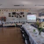 Sala w Gminnym Ośrodku Kultury przygotowana na Konferencję, w tle wystawa prac uczestników projektu