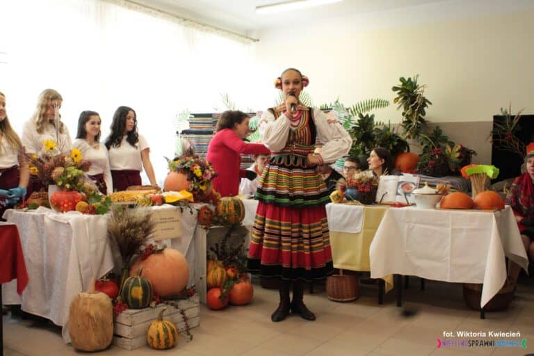 Występ wokalny Pani Natalii Czerskiej ubranej w strój ludowy, w tle stanowiska wystawiennicze