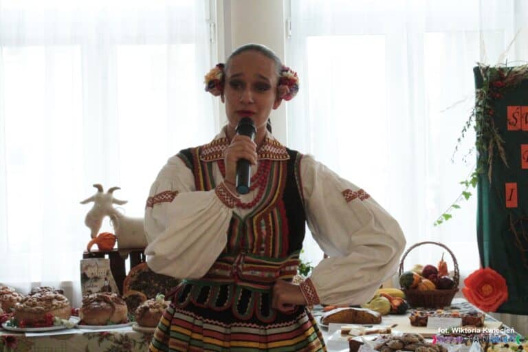 Pani Natalia Czerska z Zespołu Szkół Ponadgimnazjalnych w Niemcach ubrana w strój ludowy podczas występu wokalnego z piosenką "Hej z góry, z góry, jadą Mazury"