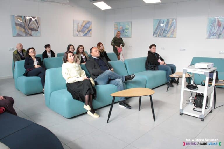 Uczestnicy wizyty studyjnej siedzą na kanapach