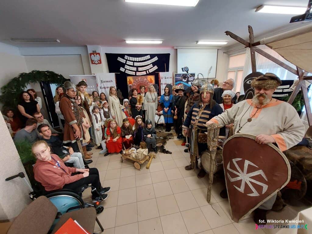 Pamiątkowe zdjęcie społeczności szkolnej oraz gości uczestniczących w inscenizacji pt. “Orszak z darami dla rodziny królewskiej w Kozim Grodzie na Wyścigowej”