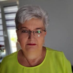 Pani Grażyna - kobieta z krrótkimi, siwymi włosami w okularach , ubrana w limonkową bluzke