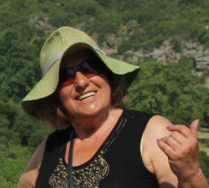 Zofia Widz-Baryła w zielonym kapeluszu na tle zalesionego szczytu.