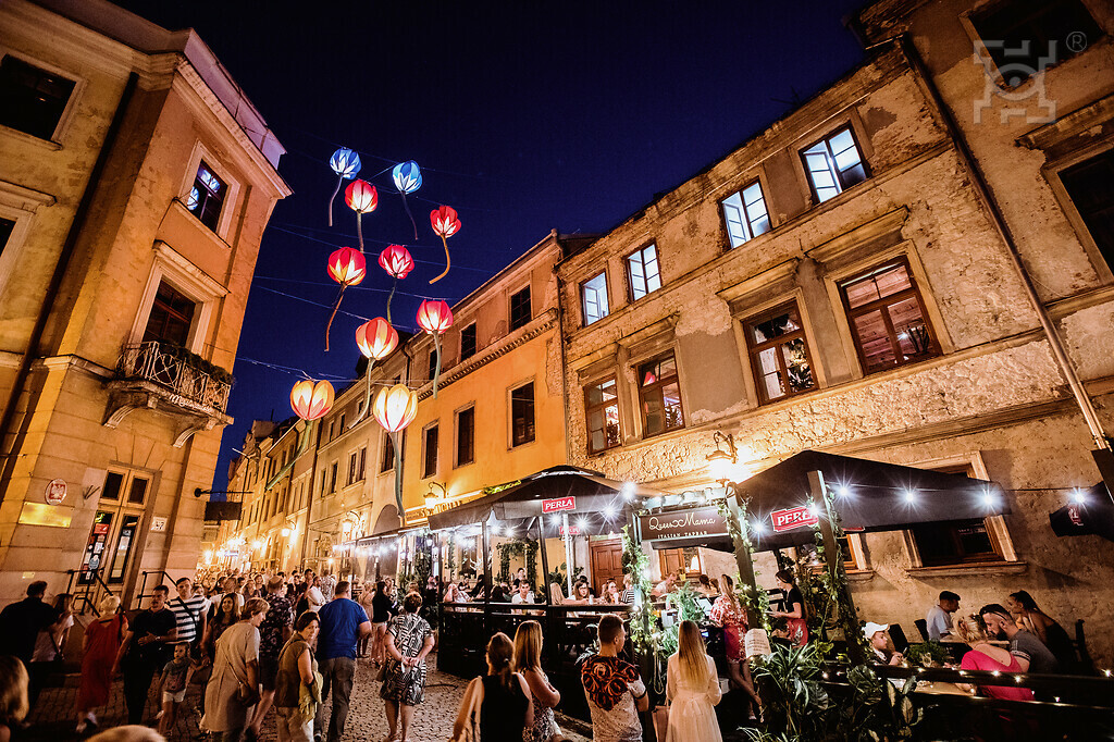 Tłum przechodniów spacerujący wieczorem na Starym Mieście.