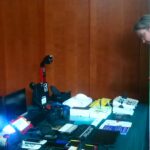 Mężczyzna przyglądający się różnym urządzeniom zaprezentowanym na stole.