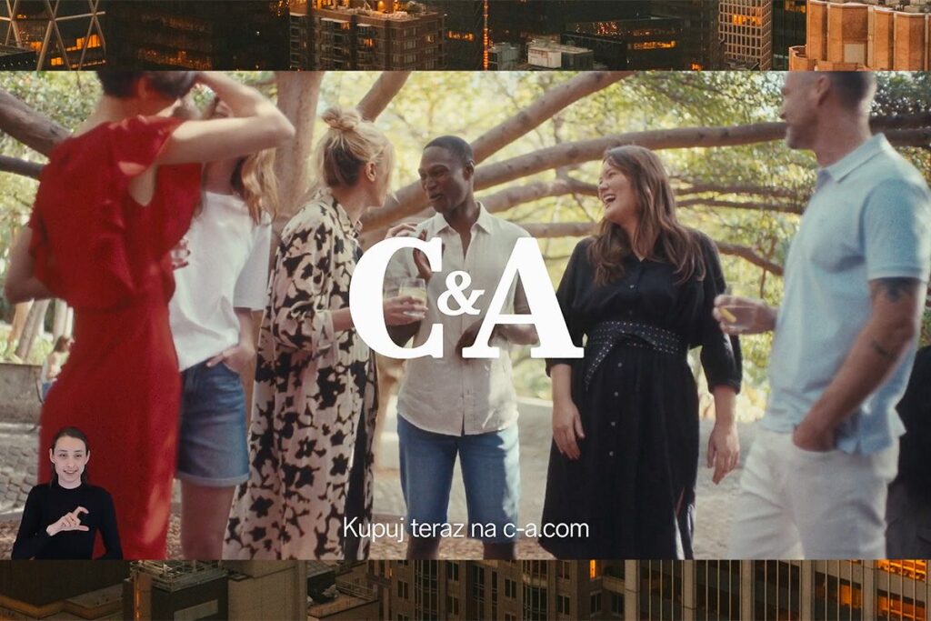 Na zdjęciu widać uśmiechniętych ludzi oraz logotyp marki C&A. W lewym dolnym rogu widnieje tłumaczka Polskiego Języka Migowego