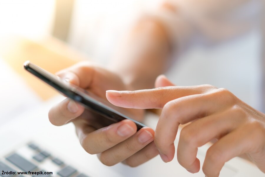 Kobieca dłoń stuka w smartfon