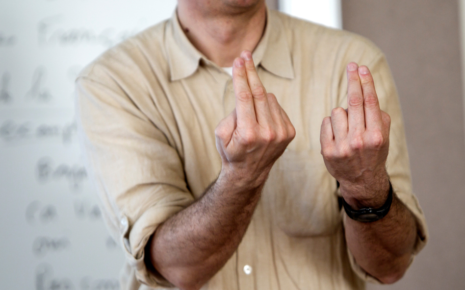 Męskie dłonie pokazujące znak w języku migowym