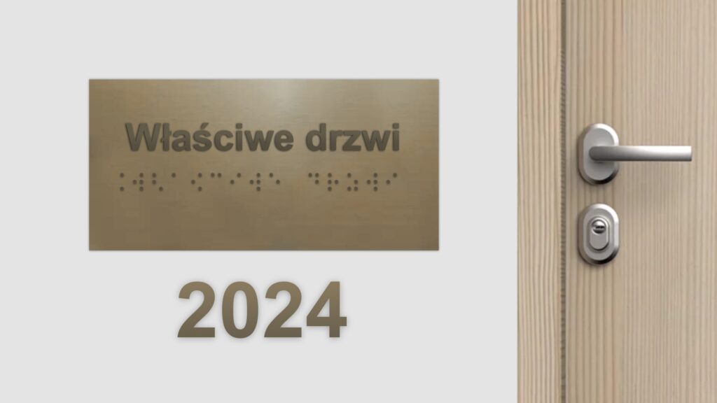 Na ścianie wisi tabliczka z napisem w czarnodruku i brajlu „właściwe drzwi.” Po prawej od tabliczki drewniane drzwi z metalową klamką. Pod tabliczką tekst: 2024.