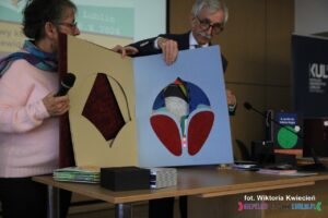 Prezentacja jednej z wyróżnionych książek, której karty mają wycięte otwory o różnych kształtach