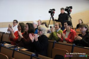 Bijący brawo uśmiechnięci Jurorzy siedzą na widowni