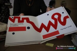 Prezentacja wnętrza książki pt. "IL GATTO DAL COLLO LUNGO", która zdobyła III miejsce i nagrodę 1000 zł. Opowiada o kocie z bardzo długą szyją, która układa się w pokazane linie geometryczne, zygzaki i zawijasy.