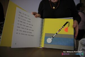 Wnętrze książki pt. "De schat van Teum", wyróżnionej za oryginalny/ważny temat. Po jednej stronie nadrukowano tekst, po drugiej jest dotykowy obrazek laski dla niewidomych