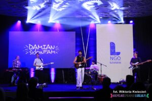 Na scenie wokalista Damian Syjonfam z towarzyszącym mu zespołem