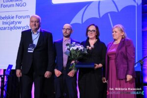 Na scenie stoją od lewej: Pan Wojciech Dec, Pan Łukasz Lewicki, Pani Anna Bieganowska-Skóra oraz Pani Ewa Rębecka