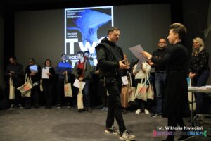 Pan Konrad Drobek podchodzi do Pani Karoliny Czajki po odbiór dyplomu