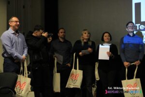 Stojący w rzędzie Uczestnicy konkursu, trzymają w rękach trzymają odebrane podziękowania za udział w konkursie