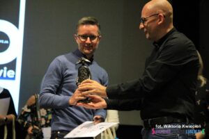 Pan Mariusz Kuszpa przekazuje posążek Panu Sebastianowi Stokłosie - Laureatowi Grand Prix - fotografii najlepiej ujmującej IDEĘ festiwalu SANS