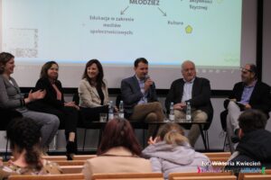 Uczestnicy panelu dyskusyjnego - widok z widowni; od lewej siedzą: Pani Dorota Krać, Pani Małgorzata Żywicka, Pani Monika Skalska, Pan Artur Kochański, Pan Wojciech Dec, Pan Robert Gostkowski