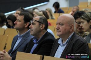 Organizatorzy i wykładowcy siedzący na widowni