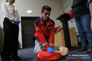 Wolontariusz Maciej prezentuje na fantomie technikę uciśnięć