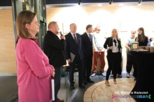 Oficjalne otwarcie wernisażu, grupa osób ustawionych w półokręgu