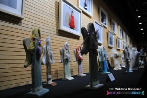 Widok stojących na blacie i wiszących na ścianie prac artystycznych o tematyce Aniołów