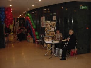 Stoiska wystawiennicze organizacji osób niepełnosprawnych w przyozdobionym kolorowymi balonami foyer Teatru Muzycznego w Lublinie