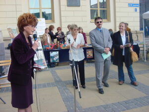 Wśród czterech stojących osób pierwsza od lewej to Pani Iwona Majewska, następnie Pani Danuta Bober, Pan Antoni Chrzonstowski (Zastępca Prezydenta Miasta Lublin) oraz Pani Alicja Jankiewicz, w tle budynek Nowego Ratusza przy Placu Władysława Łokietka 1