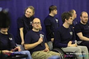 Członkowie zespołu „Rozśpiewany Zakątek” ubrani w jednakowe granatowe koszulki