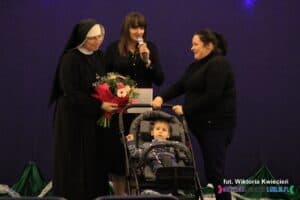 Na scenie stoją od lewej siostra Anuarita Ewa Tutka, prowadząca wydarzenie Angelika Tomasik oraz kobieta z siedzącym w wózku Maksem