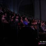 Publiczność siedząca na widowni podczas oglądania spektaklu