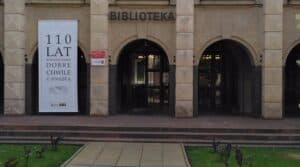 Wejście do biblioteki z banerem upamiętniającym 110-lecie czytelnictwa