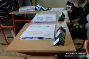 Ławki lekcyjne, na których ułożono pomoce do komunikacji alternatywnej, wykorzystywane podczas nauki