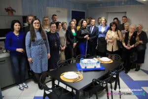 Grupowe zdjęcie pamiątkowe zaproszonych gości we wnętrzu Pracowni Czynności Dnia Codziennego