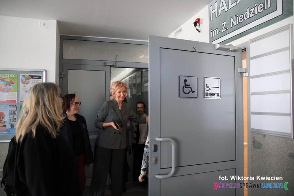 Hala im. Z. Niedzieli: Grupa kobiet stoi przy otwartych drzwiach prowadzących do toalety dla osób z niepełnosprawnościami i Komfortki