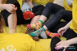 Plątanina nóg i stóp w kolorowych skarpetkach nie do pary