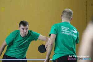 Dwóch zawodników z WTZ Misericordia w zielonych koszulkach rozgrywa mecz